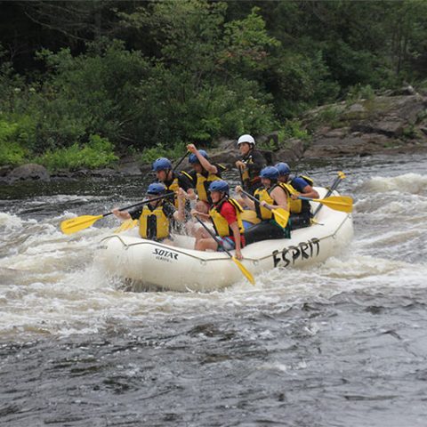 a group of people riding on a raft in the water