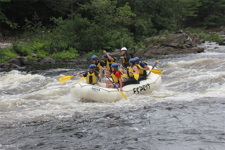 a group of people riding on a raft in the water