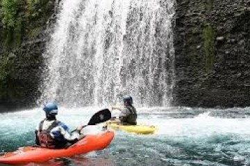 a man riding on the back of a boat in the water