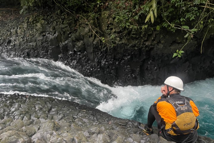 a man riding a snowboard down a river