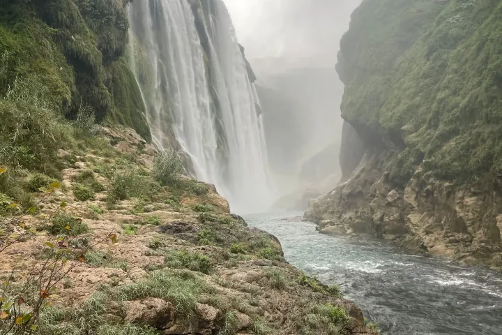 a large waterfall over a body of water